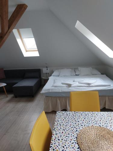 1 dormitorio con 1 cama y 2 sillas amarillas en APARTMÁNY LEDNiCE, en Lednice