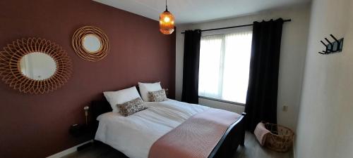 een slaapkamer met een wit bed en een raam bij Vakantiehuis de Haar Ambt-Delden in Ambt Delden