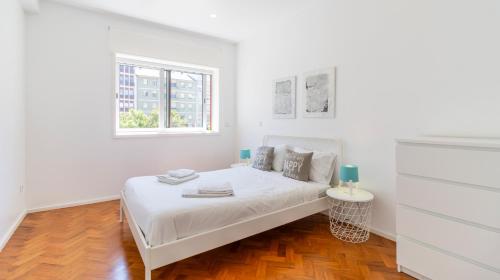 - une chambre blanche avec un lit et une fenêtre dans l'établissement Charming Bessa Apartment by Unique Hosts, à Porto