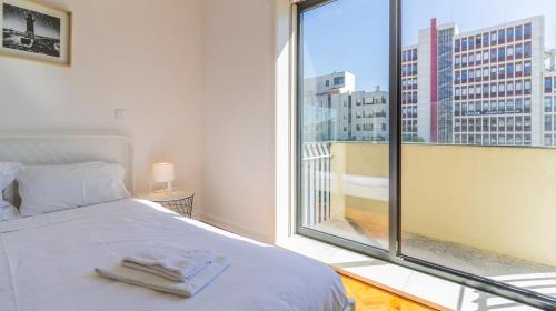 a bedroom with a bed and a large window at Charming Boavista Apartment by Unique Hosts in Porto