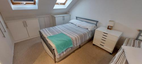 a small bedroom with a bed and a dresser at Nice 3 Bedroom House Wimbledon in London