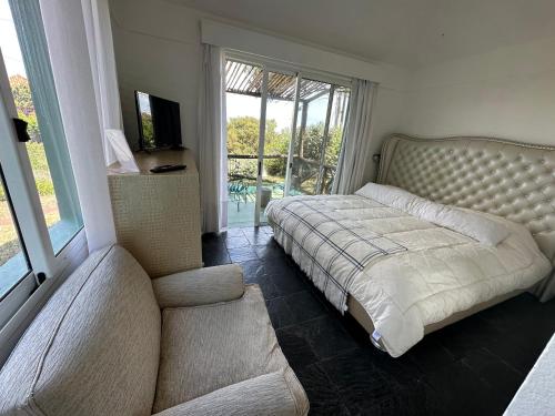 a bedroom with a bed and a couch at Hotel Boutique Donatella Mare art. in Punta del Este