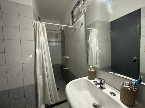bagno con lavandino, doccia e specchio di Hotel Boutique Donatella Mare art. a Punta del Este