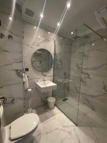 a bathroom with a toilet and a sink and a shower at Hôtel Amouday in Casablanca