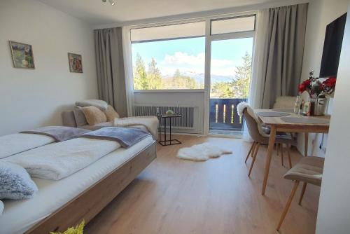 a bedroom with a bed and a desk and a large window at Bergblick 411 am Wolfgangsee in Strobl