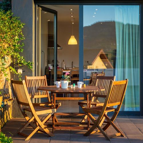 einen Holztisch und Stühle auf einer Terrasse in der Unterkunft Apartamentos Naredo in Villaviciosa