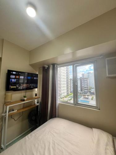 a bedroom with a bed and a large window at New Cute&Cozy Fully Furnished Studio - Avida Tower 2 - 100 Mbps wifi in Iloilo City