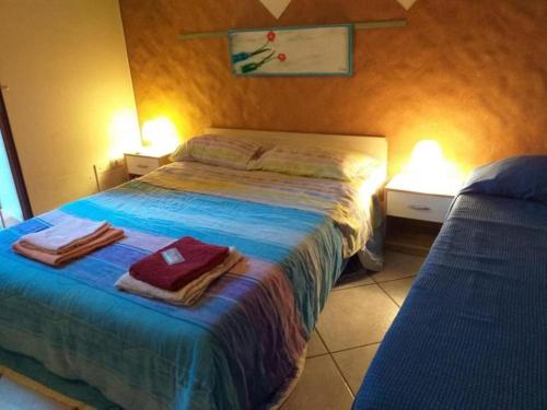 - une chambre avec un lit et des serviettes dans l'établissement Rifugio di Stazzo Holiday home for groups of 20 people, à Santa Tecla