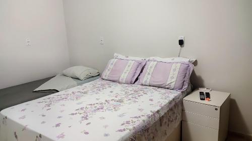 um pequeno quarto com uma cama e uma cómoda em BemVyver em Indaiatuba