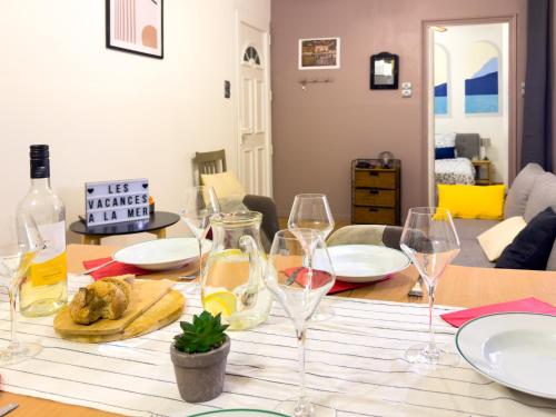 a table with wine glasses and food on it at ART appartement climatisé, 3 chambres, 5 lits, 1 min du port, cuisine équipée and jeux de société in Port-Vendres