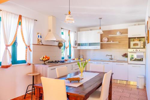 a kitchen with a wooden table and white cabinets at Villa Maha - Pool and Jacuzzi, included Breakfast in Korčula