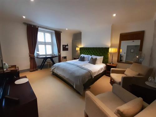Un dormitorio con una cama, una silla y un sofá. en Browns Hotel, en Dartmouth