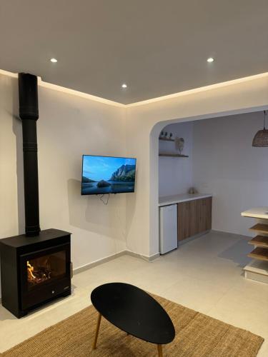 a living room with a fireplace and a tv on the wall at Pirella House in Limassol