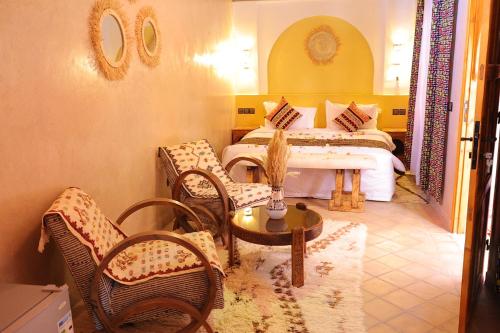 a room with two beds and a table and chairs at Riad Dar Susan - Authentic Stay in Zagora in Zagora