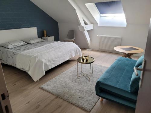 une chambre avec un lit, une table et un canapé dans l'établissement Gite le Nid de l'Erdre, à La Pouëze