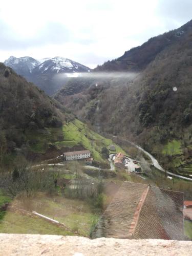 a view of a valley with snow capped mountains at OSO4 in Pola de Somiedo
