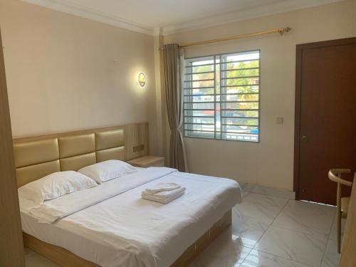 Un dormitorio con una cama con dos toallas encima. en 老骆西港宾馆, en Sihanoukville