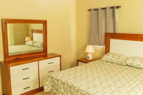 1 dormitorio con cama y tocador con espejo en Villa luxury puerto plata RD en San Felipe de Puerto Plata