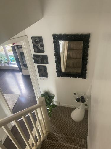 a staircase with a mirror on the wall and a mirror at Cosy Double Room in Dartford