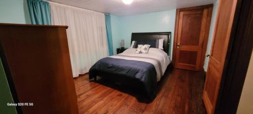 um quarto com uma cama e piso em madeira em Ethyl's Place em Port Clinton