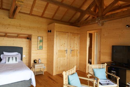 Schlafzimmer mit einem Bett und einem Flachbild-TV in der Unterkunft Le Domaine de La Tour des Vents in Bergerac