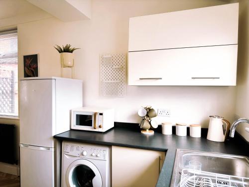 a kitchen with a white refrigerator and a washing machine at The Grange in Stockton-on-Tees