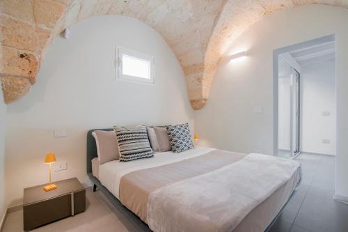 ein Schlafzimmer mit einem großen Bett in einem weißen Zimmer in der Unterkunft Chapeau Apartment - Lecce Selection in Squinzano