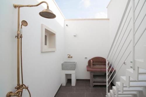 ein Badezimmer mit weißen Wänden und eine Treppe mit einem Waschbecken in der Unterkunft Chapeau Apartment - Lecce Selection in Squinzano