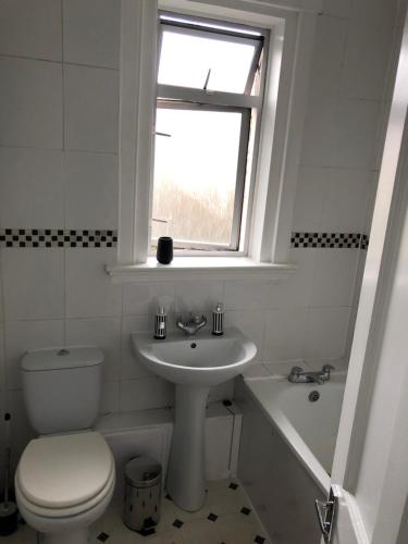 a bathroom with a toilet and a sink and a window at Dryden Gardens in Edinburgh