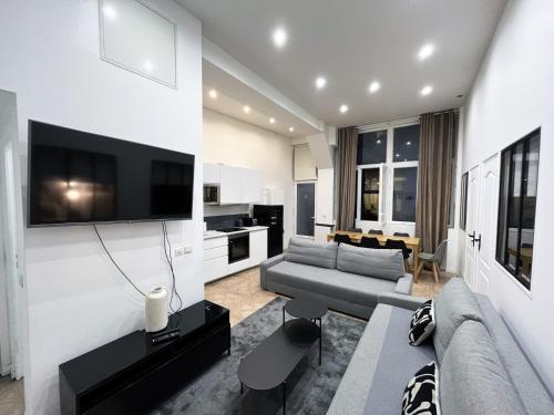 un salon avec un canapé et une télévision sur un mur dans l'établissement Urban Flat 66 - Pretty 3 bedroom in Paris, à Paris