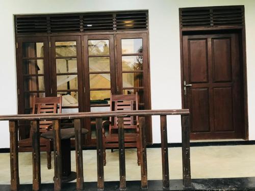 a wooden table and chairs in front of a building at Sea Glow - Tangalle in Tangalle