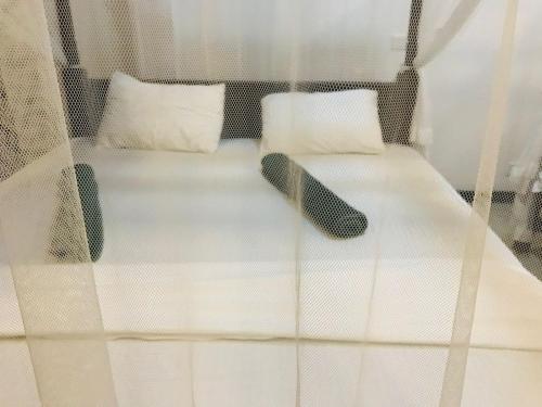 a bed with white sheets and two pillows at Sea Glow - Tangalle in Tangalle