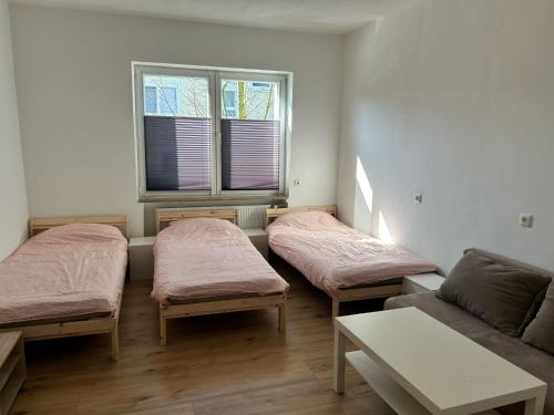 a room with three beds and a couch at Adel Kaldekirche in Essen