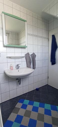 a bathroom with a white sink and a mirror at Sonnenplatz an der Weser I Nähe HDZ I Bali Therme I Kurpark I GOP in Bad Oeynhausen