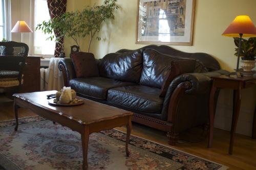 a leather couch in a living room with a coffee table at Rideau Inn in Ottawa