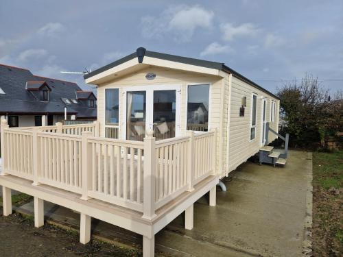 a large white house with a large deck at Harries Lodge 2 Aberaeron in Aberaeron