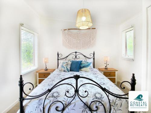 1 dormitorio con cama de hierro forjado y almohadas azules en The Purple Hen Hideaway Ramada Resort en Cowes