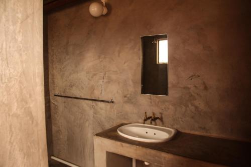 a bathroom with a sink and a mirror at Little Sossus Campsite in Maltahöhe