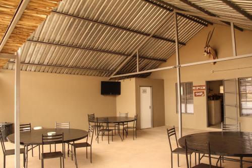 a group of tables and chairs in a room at Little Sossus Campsite in Maltahöhe