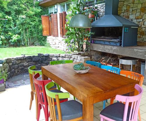 a wooden table with colorful chairs and a fireplace at Hermosa casa en barrio parque. in Mar del Plata