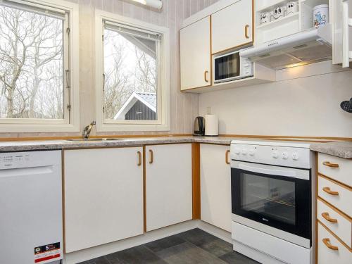 a kitchen with white cabinets and white appliances at 6 person holiday home in Hemmet in Falen