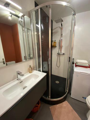 une salle de bain avec douche et lavabo dans l'établissement T2 au cœur d’Aurillac, à Aurillac
