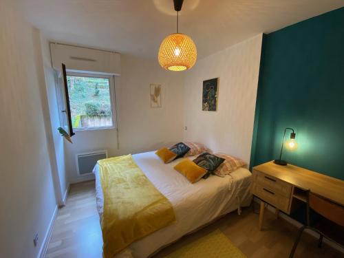 une chambre avec un lit, un bureau et une fenêtre dans l'établissement T2 au cœur d’Aurillac, à Aurillac