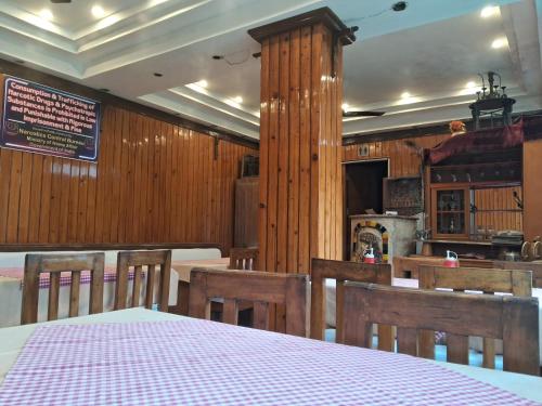 uma sala de jantar com uma mesa e paredes de madeira em HOTEL INDIA HOUSE em Dharamshala