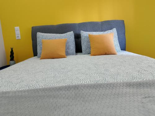 a bed with blue and orange pillows on it at Black Eagle Apartment in Drama