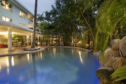 a swimming pool in front of a building at Outrigger Apartments Port Douglas in Port Douglas