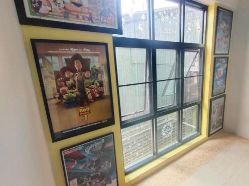 a group of posters on a wall next to windows at Qoo Hotel in Buriram