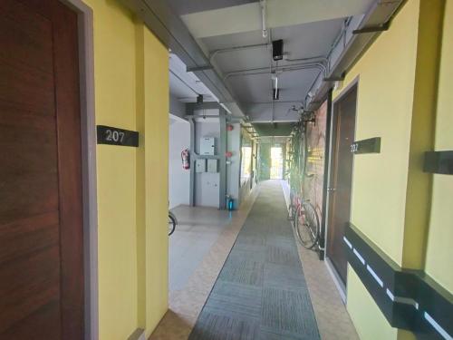 an empty hallway in a building with a bike at Qoo Hotel in Buriram