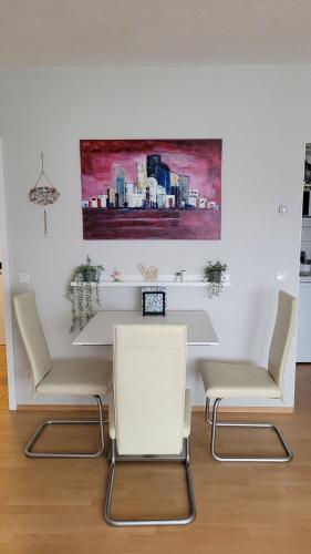 a room with three chairs and a table and a painting at Ihr Bett mit Blick auf die Weinberge in Bad Dürkheim