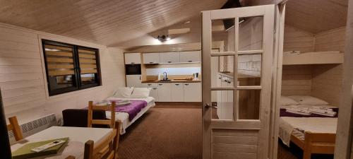 Habitación pequeña con 2 camas y cocina en Kantadaj Village Domki Prestige, en Prudnik